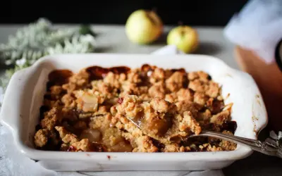 Une cuillère prélève une portion généreuse de ce vrai recette crumble aux pommes caramélisées, fondant et croustillant.