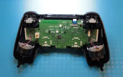 Wnętrze pada PS4 z widoczną płytką drukowaną i elementami. Dowiedz się, jak zresetować pada PS4, gdy napotkasz problemy.