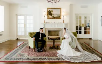 Para młoda siedzi naprzeciwko siebie w eleganckich fotelach, przeżywając ostatnie chwile przed ślubem.