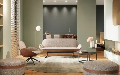 Modernes Wohnzimmer mit einem stilvollen Sofa als Raumteiler. Ein Sessel, Hocker und ein Kamin schaffen Gemütlichkeit.