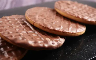 Czekoladowe ciastka digestive ułożone na czarnym tle. Idealne na popołudniową herbatę.