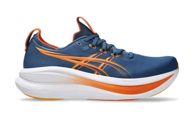 Granatowe buty do biegania z pomarańczowymi akcentami, idealne na maraton. Lekkie i amortyzujące, zapewnią komfort na długich dystansach.