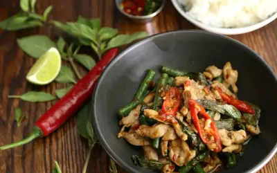 Kurczak z fasolką szparagową i chili, jedno z najpopularniejszych dań kuchni tajskiej, podany z ryżem.