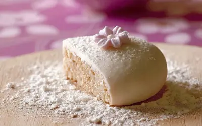 Gâteau recouvert de pâte à sucre, saupoudré de sucre glace. Une petite fleur en pâte à sucre décore le dessus. Parfait pour une recette de pâte à sucre.