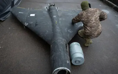 Ein Soldat inspiziert eine Drohne in Rumänien. Daneben liegt eine Munitionshülse.