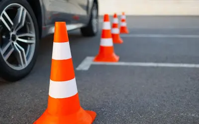 Pomarańczowe pachołki wyznaczają trasę na placu manewrowym. B+E to kategoria prawa jazdy, którą można zdobyć, ćwicząc na takim torze.