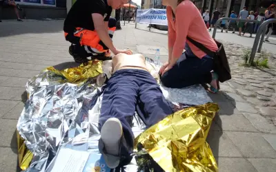 Ćwiczenia pierwszej pomocy: pozycja czterokończynowa przy omdleniu na kocu termoizolacyjnym.