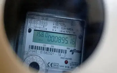 Cyfrowy licznik energii elektrycznej z wyświetlaczem pokazującym 895,16 kWh. Widoczne oznaczenia RS-485 i kody obis.