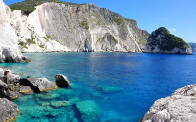 Turkusowe wody Zatoki Wraku, otoczone białymi klifami, tworzą malowniczy krajobraz w okolicach miasta Zakynthos.
