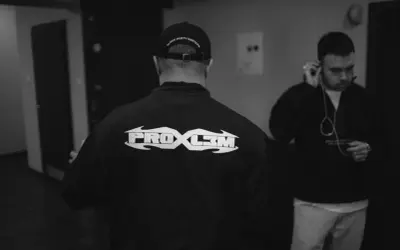 Dwóch mężczyzn, jeden w czapce z napisem "block party mixtape", drugi słucha muzyki. Na bluzie pierwszego widnieje napis "PROBL3M".