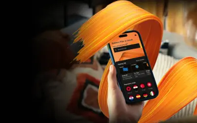 Dłoń trzyma smartfon z aplikacją do wyboru pakietów GB na **orange flex roaming**. Widoczne kraje popularne i strefy UE.