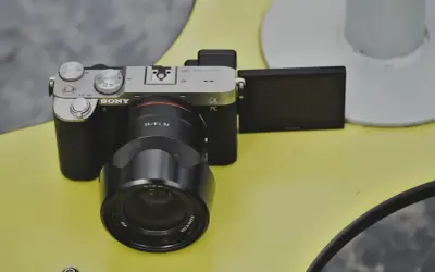 Aparat Sony a7c z obiektywem FE 1.8/35 na żółtym tle.