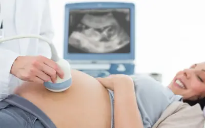 Radość przyszłej mamy podczas badania USG. Lekarz wykonuje badanie ultrasonograficzne, a na ekranie widać obraz dziecka.