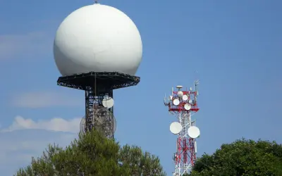 Duża biała kopuła, prawdopodobnie najlepszy radar pogodowy, góruje nad wieżą telekomunikacyjną.