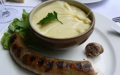 Saucisse grillée et purée onctueuse, un plat traditionnel auvergnat réconfortant.