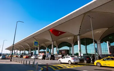 Nowe lotnisko w Bodrum tętni życiem. Samochody i taksówki czekają na pasażerów pod nowoczesnym zadaszeniem.