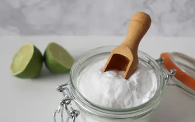 Bicarbonato e lime, ingredienti naturali per combattere la forfora. Un cucchiaino di bicarbonato in un barattolo di vetro.