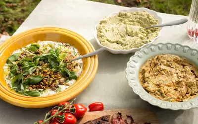 Tre skålar med röror, en med yoghurt och nötter, en grön och en orange, perfekt gott till grillat.