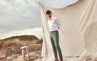 Uomo con pantaloni verdi abbinamento perfetto per un look casual chic sulla spiaggia.
