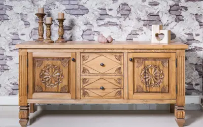 Buffet en bois sculpté, prêt à recevoir une nouvelle teinte. Ses portes ornées de motifs étoilés et ses tiroirs invitent à le teindre un meuble en bois déjà teint pour un relooking.