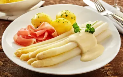 Spargel mit Sauce Hollandaise, Salzkartoffeln und Schinken. Die Menge der Sauce pro Person ist großzügig bemessen.