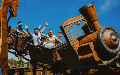Rodzina na drewnianym rollercoasterze, który wygląda jak lokomotywa. To jeden z największych rollercoasterów w Europie, zapewniający mnóstwo emocji.
