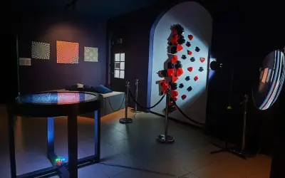 W muzeum iluzji Warszawa zobaczysz optyczne triki i instalacje, jak ściana z kartami i stołem z efektem wodnym.