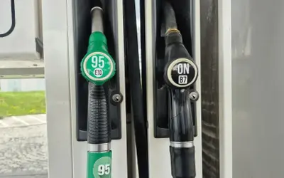 Dwa dystrybutory paliwa na stacji. Zielony z napisem "95 E10" i czarny z napisem "ON B7". Wybieram benzynę 95.