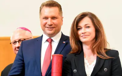 Przemysław Czarnek z żoną, Katarzyną, podczas uroczystości. Z tyłu widoczny biskup.