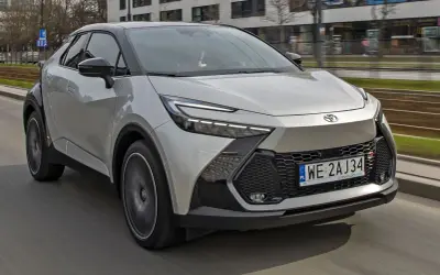 Nowa Toyota C-HR w kolorze srebrnym pędzi po mieście. Zastanawiasz się, ile kosztuje nowa Toyota C-HR? Ten stylowy crossover zachwyca designem.