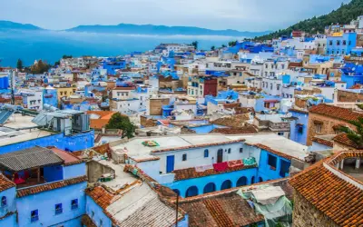Niebieskie miasto Maroko, Chefchaouen, wznosi się na wzgórzu, tworząc malowniczy krajobraz z dachówkami i błękitnymi ścianami.