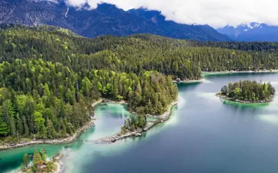 Idyllischer Bergsee mit Inseln, umgeben von dichten Wäldern. Perfekt für einen erfrischenden Tag zum schwimmen.