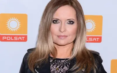 Kobieta z blond włosami i mocnym makijażem, w czarnej ramonesce, pozuje na tle logo Polsatu. Czy Gozdyra ma męża?