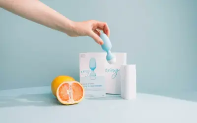 Main d'une femme tenant une sonde pour rééducation périnéale. Le produit, une sonde pour rééducation périnéale, est présenté avec des fruits. Pas d'effets secondaires connus.
