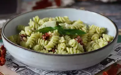 Pastasallad med krämig pesto, pinjenötter, ost och smakrika soltorkade tomater. En härlig sommarrätt.