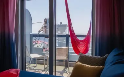 Cabina balcone vista parziale MSC con amaca rossa e cuscini accoglienti.