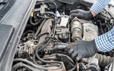 Mechanik w rękawiczkach naprawia silnik Renault, być może z powodu błędu dtc p0141.