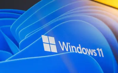 Nawet stary komputer może działać z Windows 11, pokazany na niebieskim tle z logo.