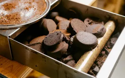 Zwarte, zbite krążki kawy w metalowym pojemniku. Tak powinny wyglądać fusy z ekspresu po zaparzeniu idealnego espresso.