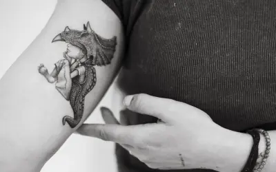 Un tatuaje de un niño con un casco de dinosaurio, con detalles intrincados, que evoca la magia de los tatuajes sevillanos.
