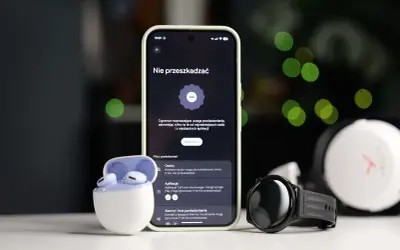 Smartfon z włączonym trybem nie przeszkadzać Samsung, obok słuchawki i smartwatch.