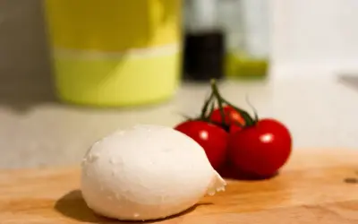 Frische Mozzarella und Kirschtomaten auf einem Holzbrett. Perfekt für eine leichte Mahlzeit während der Schwangerschaft.