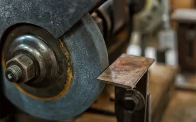 Zbliżenie na kamień szlifierski i metalowy element, pokazujące różne rodzaje kamieni szlifierskich w akcji.
