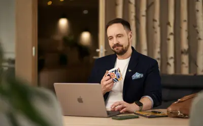 Man med kaffemugg vid laptop, funderar på firmabil regler.
