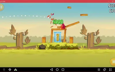 Gra Angry Birds na emulatorze. Czerwony ptak niszczy konstrukcję, zdobywając 5000 punktów.