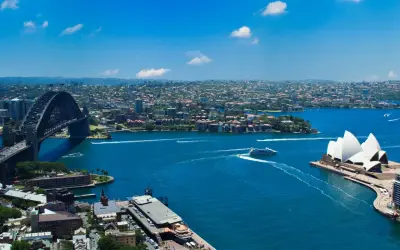 Widok na Zatokę Sydney z Operą i mostem Harbour Bridge. To właśnie Sydney, gdzie błękitna woda lśni w słońcu.