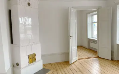 Vitt, vackert kakelugn med mässingsluckor. Tänk att elda i kakelugn en kall vinterdag.