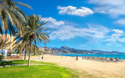 Malaga plaże: palmy, złoty piasek, turkusowe morze i góry w tle. Idealne miejsce na relaks.