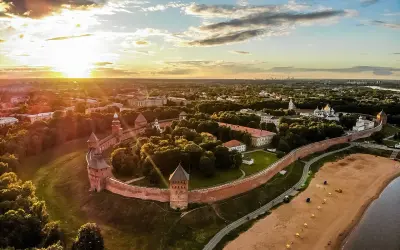 Solnedgång över Novgorod, en historisk stad med en imponerande kreml. Denna vy liknar en gammal **Novgorod karta** med sina befästningar och gyllene kupoler.