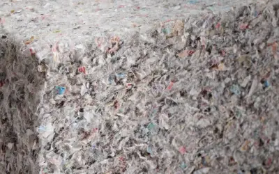 Materiały budowlane: celuloza ocieplenie z recyklingu, tworzące zwartą, włóknistą strukturę z kolorowymi fragmentami.